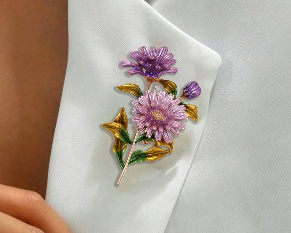 Close-up of a luxurious brooch featuring purple flowers with golden leaves and green enamel stems