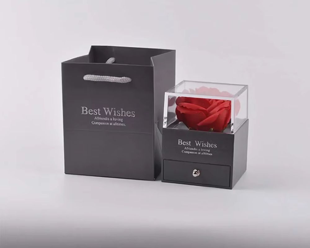 Black box with a preserved red rose and “Best Wishes” embossed—because gifting should always feel this special.