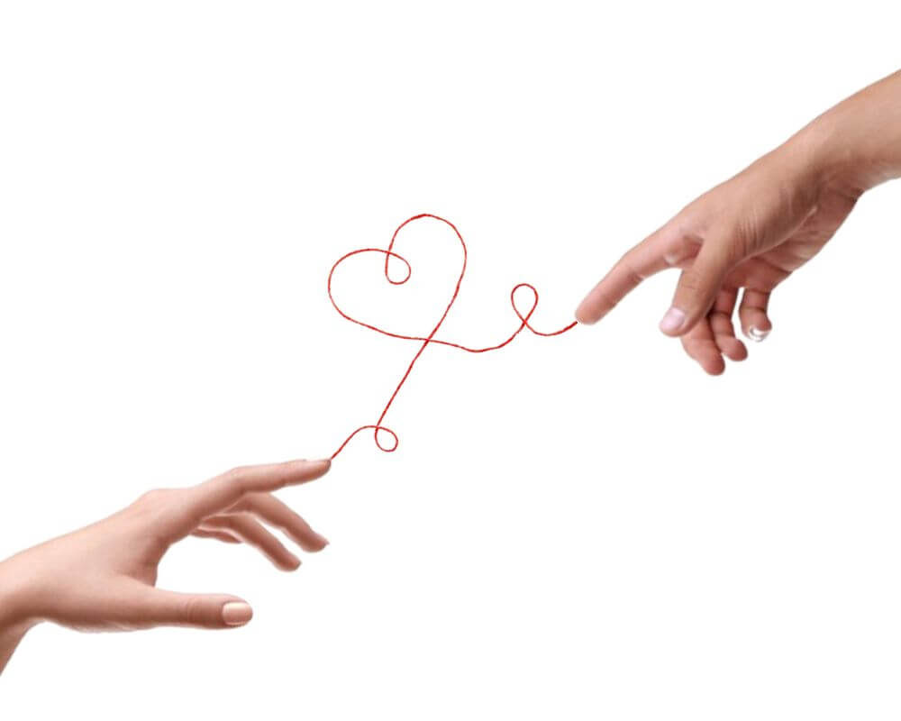 Hands connected by a red string forming a heart, symbolizing the romantic essence of a first date